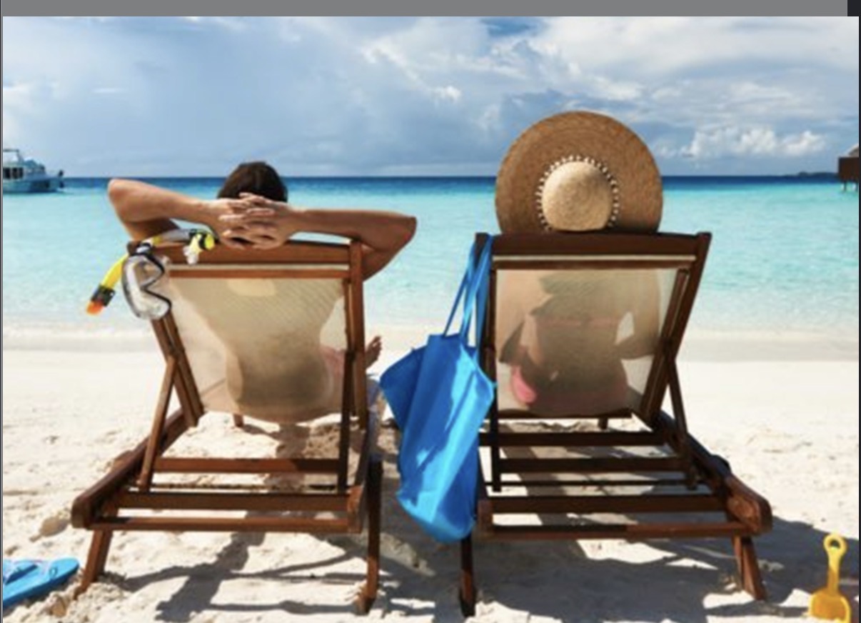 Two loungers on a white sand beach by turquoise water